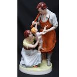 A large Royal Dux figure of a blacksmith with his wife and child, standing on a naturalistic base,