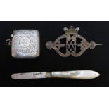 A silver and mother of pearl fruit knife; an engraved silver vesta case and a silver brooch (3).