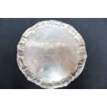 A George II silver salver, the centre engraved with a family crest, having a scroll and shell rim on