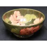 A Walter Moorcroft Hibiscus pattern tube lined bowl, decorated with peach-coloured flowers on a