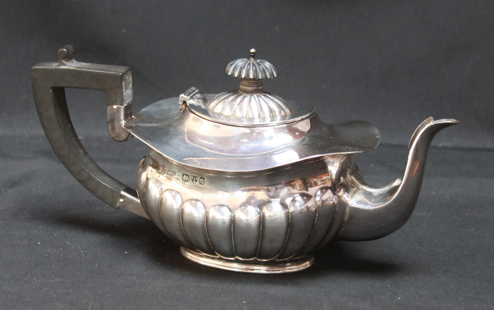 A Victorian semi-fluted silver teapot, hallmarked Chester 1899, of oval form with ebonised knop