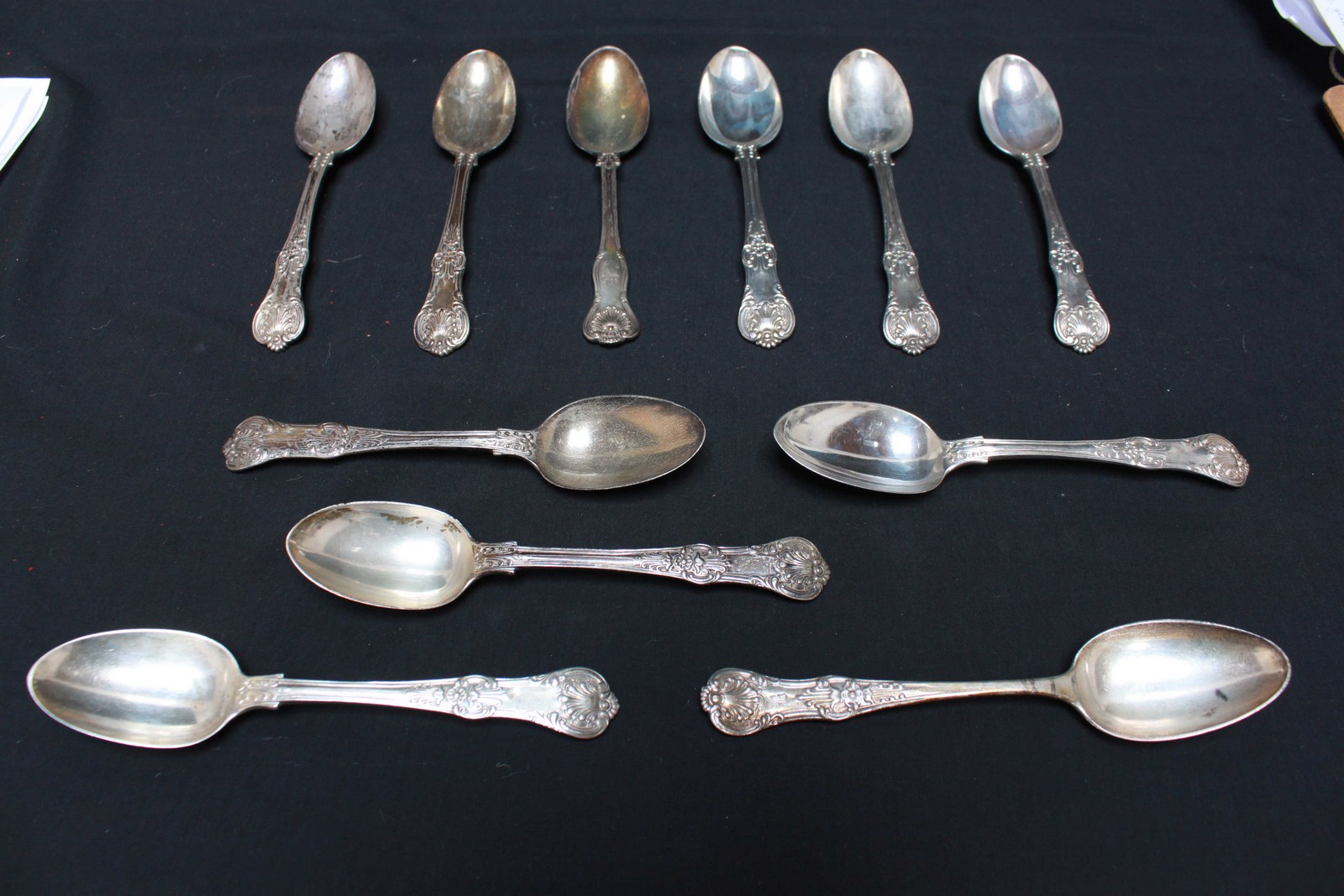 Eleven Kings pattern silver dessert spoons, various makers and dates, 21oz.