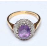 An 18ct gold and amethyst ring, set with oval mixed-cut amethyst surrounded by 19 Swiss cut diamonds