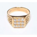 An 18ct gold and diamond ring, set with nine diamonds in a square, in a carved and scrolled mount,