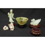 A jade tea-bowl, carved jade duck and female figure all on wooden stands, together with two resin