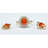 An 18ct gold and diamond dress ring, centrally set with an oval mixed-cut Mandarin garnet surrounded