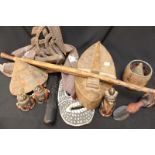 A collection of tribal artefacts including two masks, walking sticks, figures and basketry items