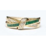 A 9ct gold, diamond and emerald ring formed as two tied-rings, the bow and one ring set with