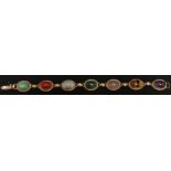 A 9ct gold oval hard stone bracelet, set with seven various cabochon semi-precious stones. 19 cm