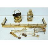 A large collection of brassware including a fender, coal bucket, fire tools, a ships lantern and