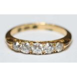 An 18ct gold and diamond five stone ring, set with larger central diamond flanked either side by