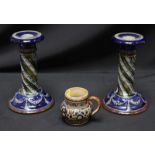 A pair of Royal Doulton stoneware candlesticks, with spiral stems and wreath mounted bases,