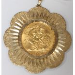 A 1968 22ct gold full sovereign in a 9ct gold flower shaped mount. Total weight 14.3 grams.