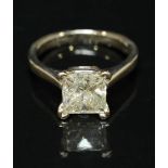 A 14k white gold solitaire diamond ring corner set with a princess cut diamond, the diamond weighing