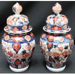 A pair of late 19th century Japanese Imari vases and covers, decorated with flowers. 22.5 cm high.