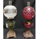 Two Victorian glass oil lamps, one with cranberry reservoir and bulbous shade, the other with