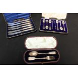 A cased set of six silver teaspoons and sugar tongs, together with a set of six silver handled