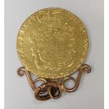 A 1775 George III 22ct gold one guinea coin, with 9ct gold soldered mount. Worn. 9.5 grams.