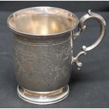 A Victorian silver mug, hallmarked 1867 with scrolled handle and engraved decoration. Makers mark: