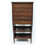 An early 20th century stained walnut five-drawer music cabinet, the drawers with hinged fronts,