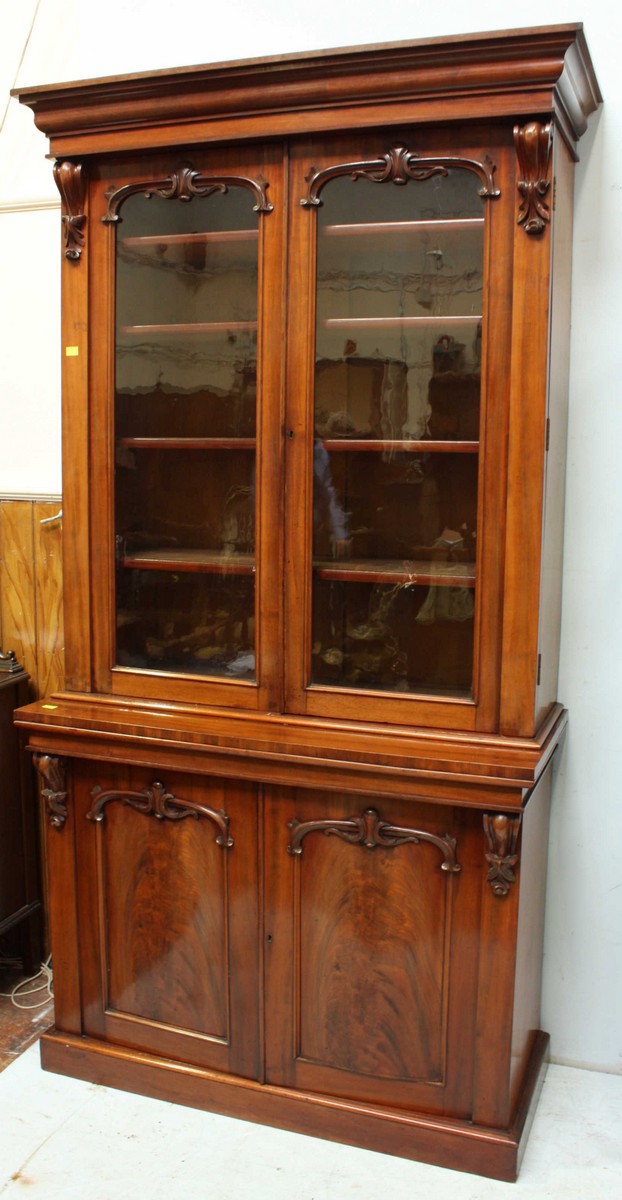 A large Victorian mahogany standing bookcase, the top with a pair of glazed doors enclosing