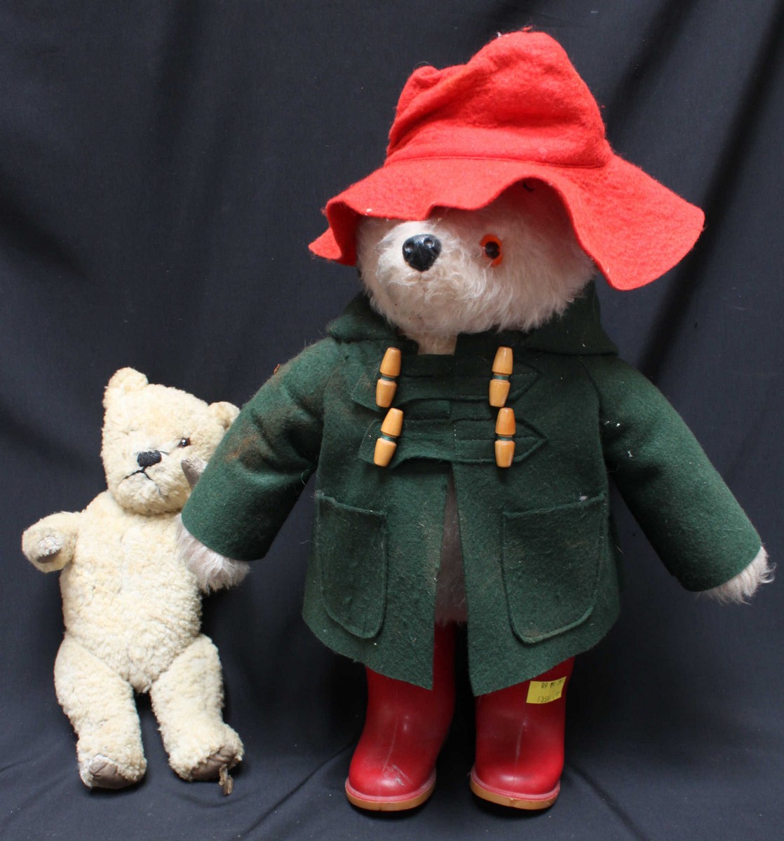 A large Paddington Bear stuffed teddy, with red hat and wellington boots, and a green jacket and