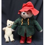 A large Paddington Bear stuffed teddy, with red hat and wellington boots, and a green jacket and