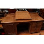 A large pine pedestal clerk’s desk, the top with raised sloping writing surface, well within, and
