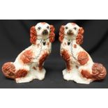 A pair of 19th century Staffordshire pottery models of seated Spaniels, iron red patches, 32cm high