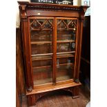 A large Victorian style carved mahogany two door bookcase, in the Gothic design, with carved