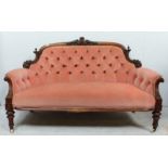 A Victorian carved walnut button back settee, with foliate carved show wood frame, pink velvet