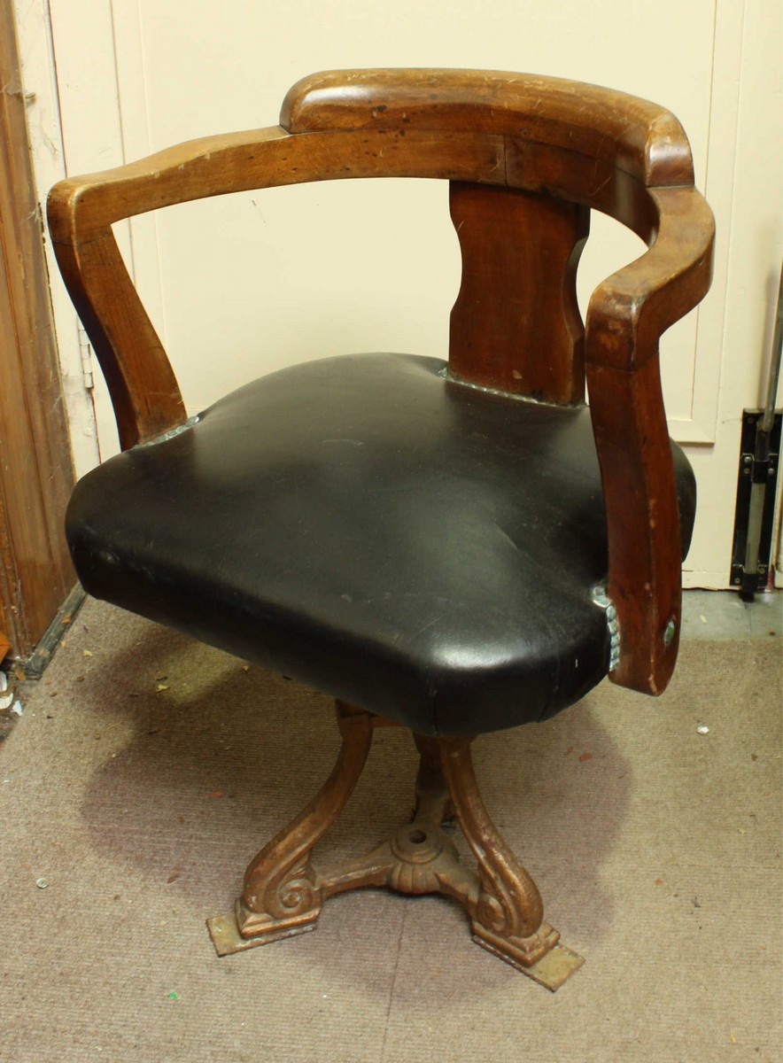 An early 20th century mahogany revolving tub chair, with padded seat, supported on a cast iron