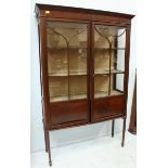 A large Edwardian mahogany two door display cabinet, with a pair of astragal glazed doors