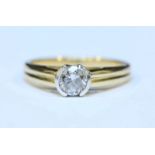 An 18ct gold solitaire diamond ring rub-over set with a round brilliant cut diamond, the diamond