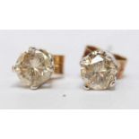 A pair of diamond solitaire earrings, each claw-set with a round brilliant cut diamond, estimated