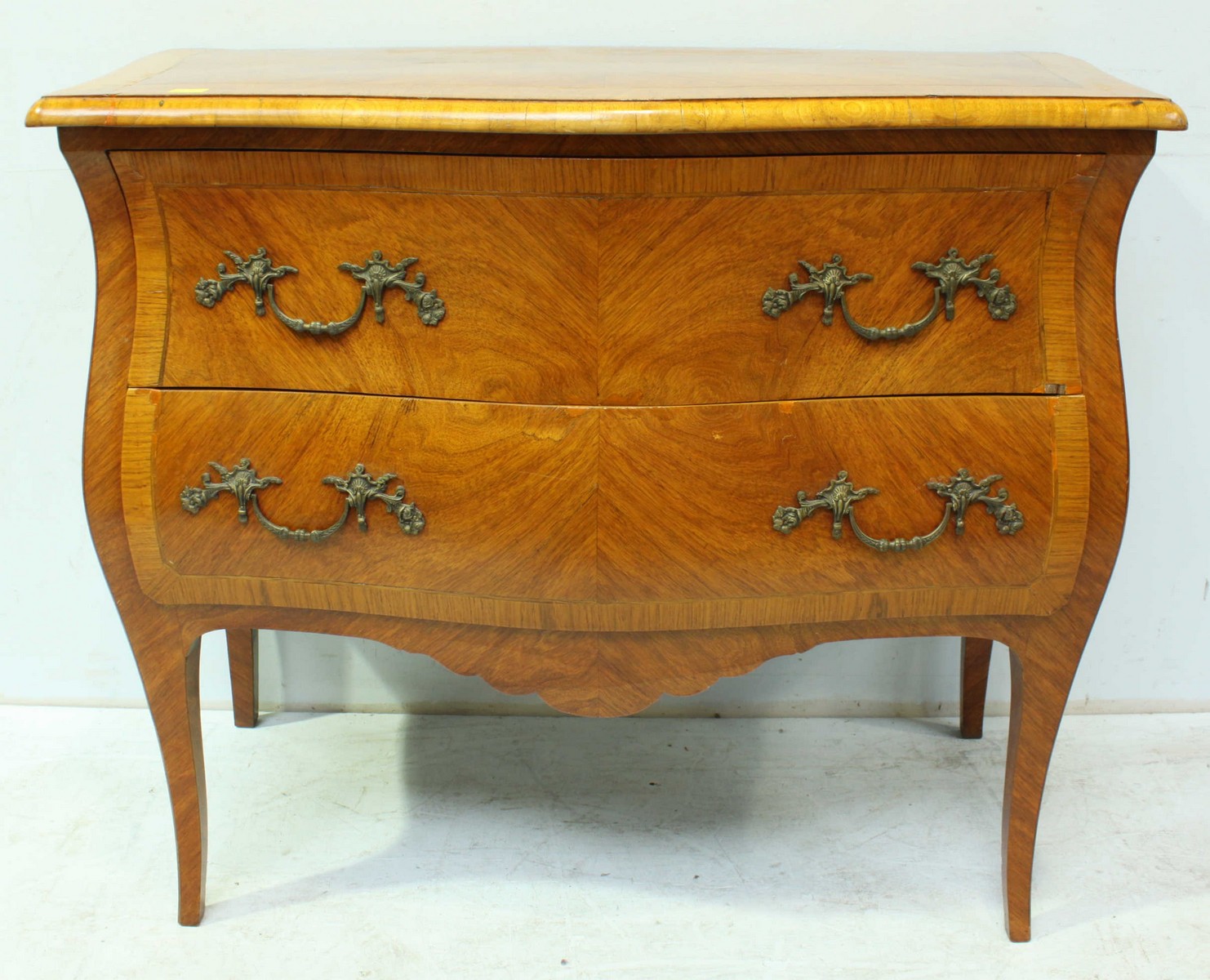 An early 20th century French kingwood parquetry veneered bombe commode, with serpentine front and