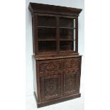 A large early 19th century Continental carved oak bookcase, the top with a pair of glazed doors