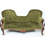 A Victorian carved mahogany double camel back sofa, with carved foliate show wood frame and