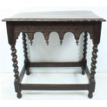 An oak occasional table with shaped and carved frieze decoration, raised on barley twist supports,