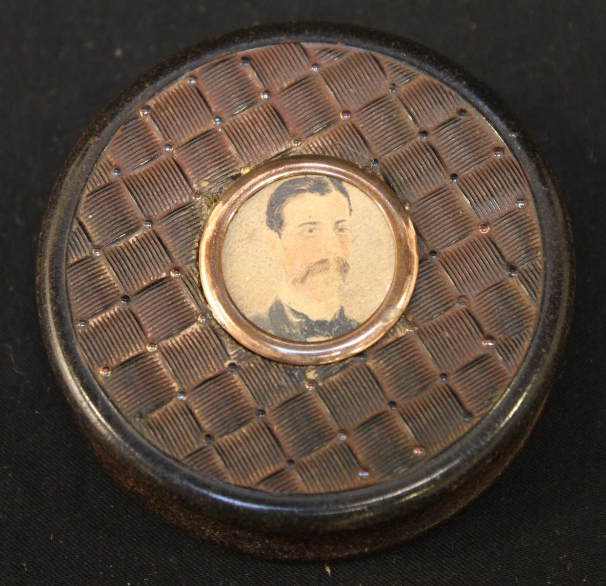 A 19th century tortoiseshell circular pill box, the lid inset with a small watercolour portrait of a