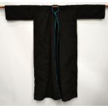 Ottoman black goat-hair coat, completely plain with the exception of a narrow turquoise braid to the