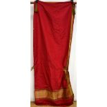 Middle eastern hooded cape of deep red silk edged with gold coloured metal thread brocade and with a