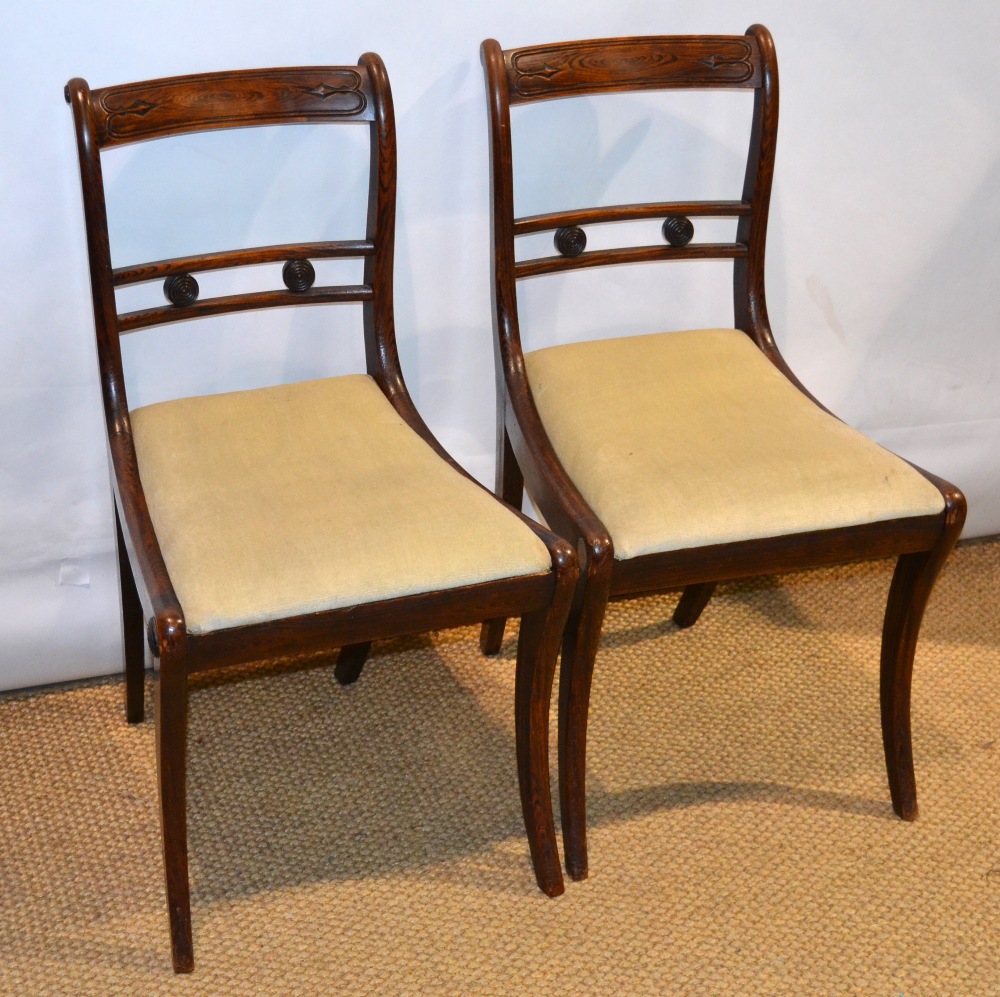 A pair of Regency, rosewood grained, beech frame side chairs, with rondels to the rail backs, fawn