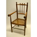 A nineteenth century child's beech armchair, simulating bamboo, with a caned seat, on stretchered