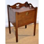 A Sheraton mahogany bedside cupboard, the serpentine shaped gallery top with pierced hand grips, a
