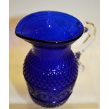 An early nineteenth century Bristol blue pressed glass cream jug, with swirl moulded neck, a band of
