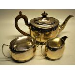 A bachelors silver three piece oval tea service, the teapot with a swan neck spout, composite finial