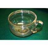 A unusual early nineteenth century glass sick pot, with folded rim, a scroll handle. 5.5in (14cm)
