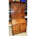 An early eighteenth century oak bureau bookcase, the top with a moulded cavetto cornice, the