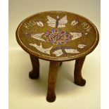 A Kenyan hardwood stool, the dish seat with red, white and blue beadwork of insects, butterflies and